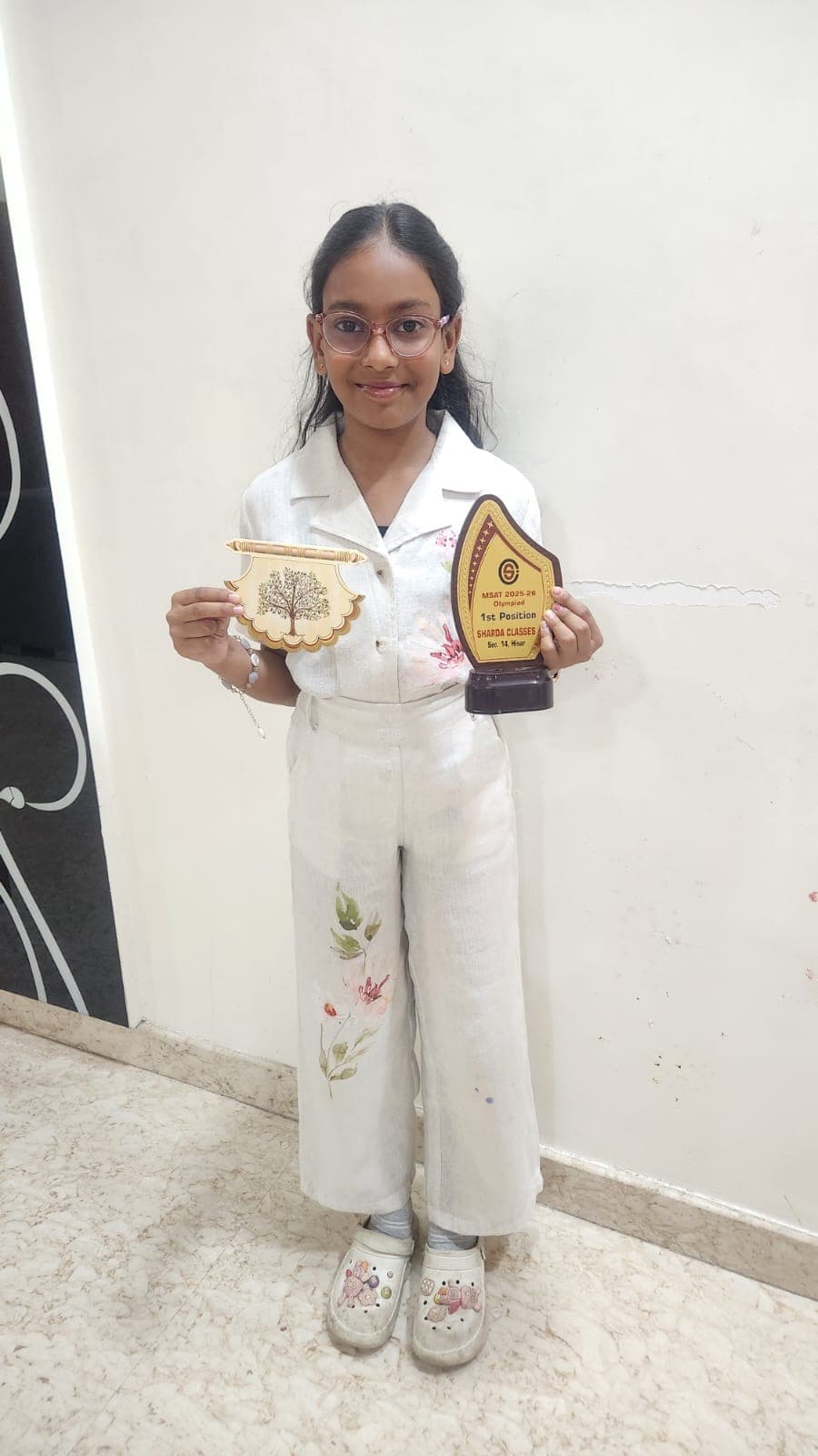 Khushi proudly holding her trophies and awards