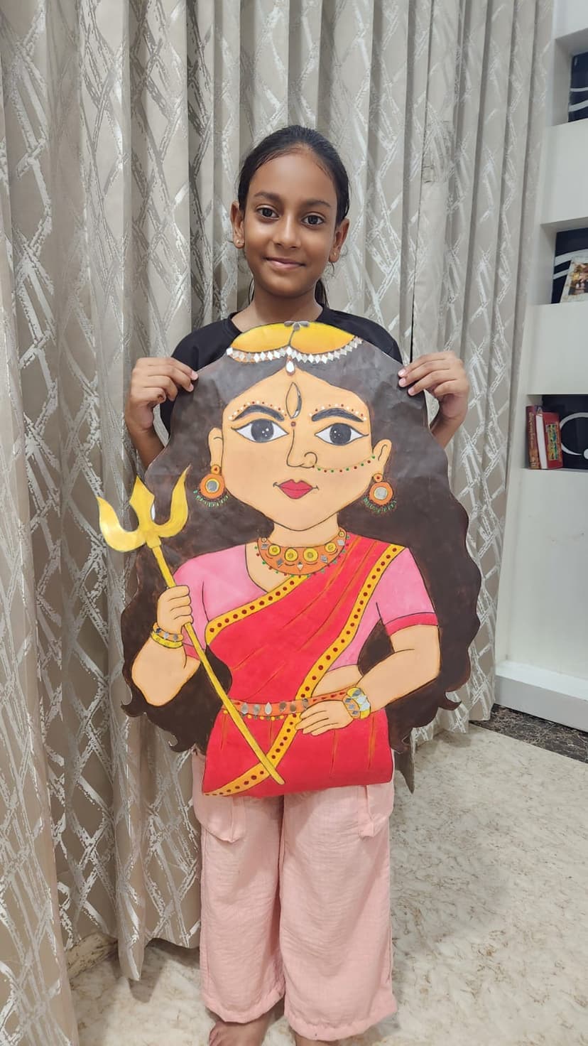 Khushi holding handmade Durga Maa cutout