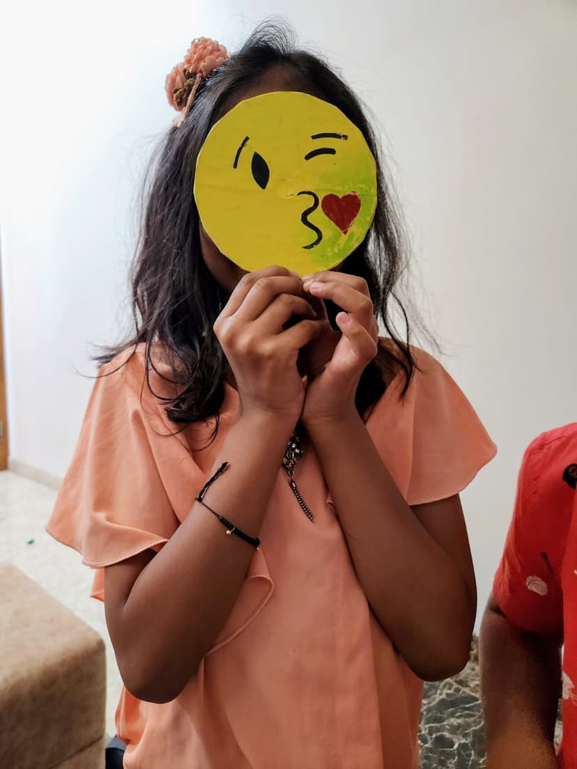 Khushi with handmade emoji face craft