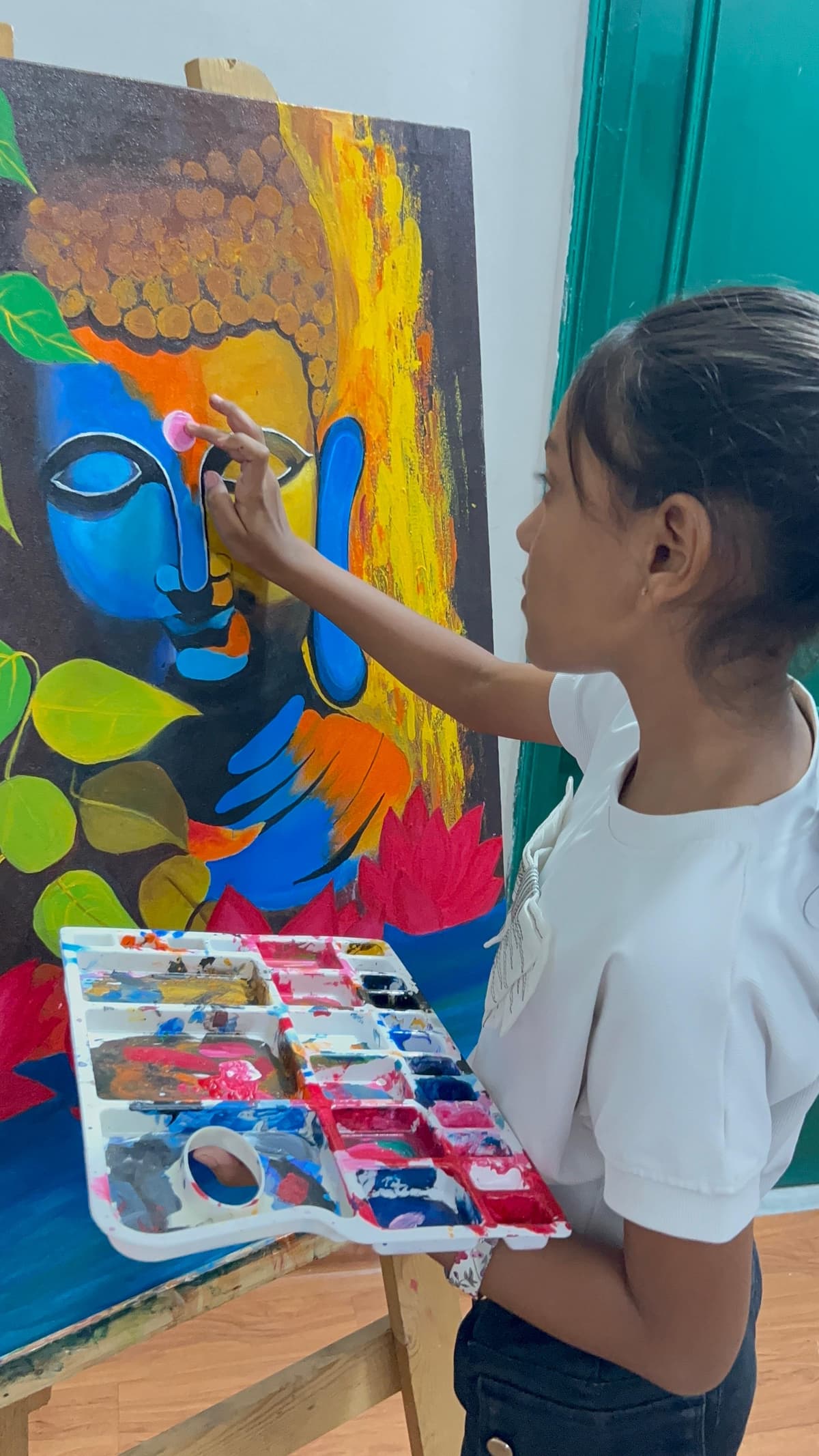 Khushi painting a beautiful Buddha canvas with vibrant colors