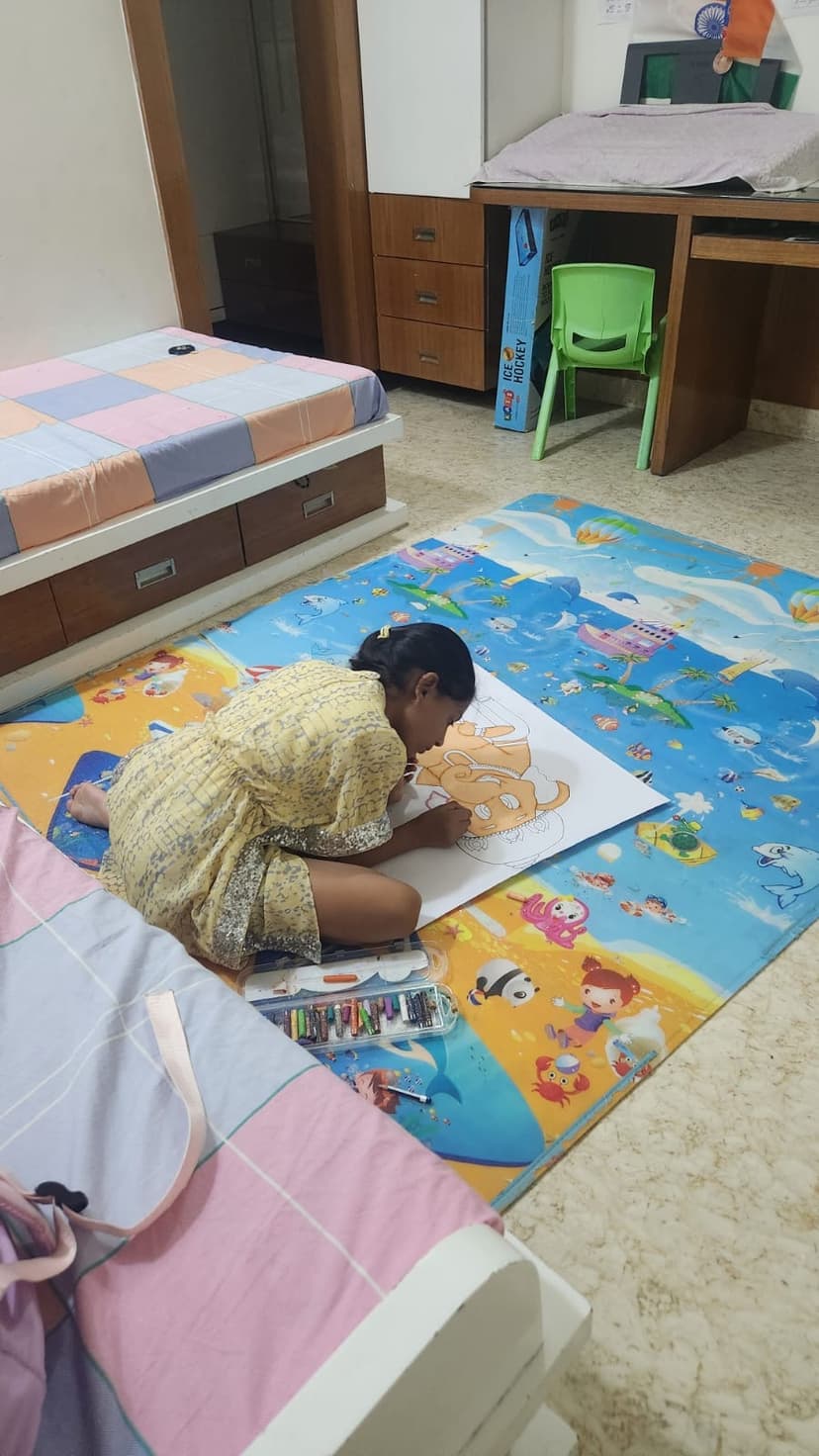 Khushi painting a large artwork on the floor